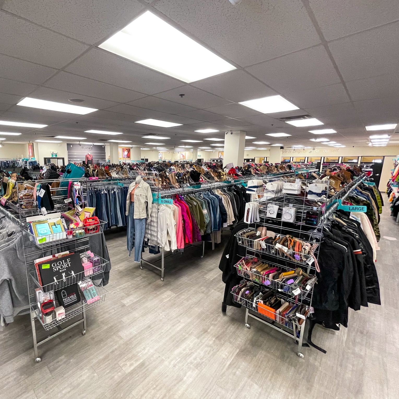 Picture of Plato's Closet London interior. Racks with clothes and shoes.